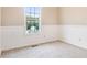 Inviting bedroom with a window providing natural light and lower wall trim detail, creating a comfortable and serene ambiance at 421 River Trace Dr, Villa Rica, GA 30180