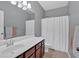 Well-lit bathroom featuring a large mirror, vanity with storage, and shower with a white curtain at 4349 Kousa Rd # 4, Austell, GA 30106