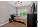 Comfortable bedroom including a ceiling fan, wood floors, and a large window at 4349 Kousa Rd # 4, Austell, GA 30106