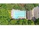 An aerial shot of a beautiful community pool surrounded by lush greenery, lounge chairs, and a pool house at 4349 Kousa Rd # 4, Austell, GA 30106