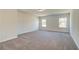 Spacious carpeted bedroom with natural light from two windows and neutral walls at 443 Lothbury Ave, Locust Grove, GA 30248