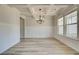 Elegant dining room features a coffered ceiling, wainscoting, a modern chandelier, and ample natural light at 443 Lothbury Ave, Locust Grove, GA 30248