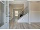 Welcoming foyer with staircase, wood floors, and natural light streaming through the doorway and window at 443 Lothbury Ave, Locust Grove, GA 30248