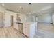Open-concept kitchen with island, stainless steel appliances, pendant lighting and hardwood floors at 443 Lothbury Ave, Locust Grove, GA 30248