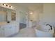 Bright main bathroom features a freestanding tub, dual sinks, marble tile, and a separate shower at 443 Lothbury Ave, Locust Grove, GA 30248