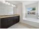 Bright bathroom with a soaking tub, a double vanity, and a large window at 6761 Cedar Glen Rd, Peachtree Corners, GA 30360