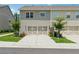Charming townhome exterior with a two-car garage, well-maintained lawn, and landscaped yard at 6761 Cedar Glen Rd, Peachtree Corners, GA 30360