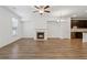 Open-concept living room with fireplace, hardwood floors, and kitchen view at 6761 Cedar Glen Rd, Peachtree Corners, GA 30360