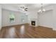 Bright living room with wood floors, fireplace, and modern ceiling fan and chandelier at 6761 Cedar Glen Rd, Peachtree Corners, GA 30360