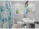 Bright bathroom featuring a pedestal sink and patterned shower curtain at 1959 Audubon Ne Dr, Atlanta, GA 30329