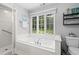 Bright bathroom showcasing a luxurious soaking tub with jets, a separate glass shower, and a large window at 1959 Audubon Ne Dr, Atlanta, GA 30329