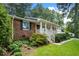 Brick home features a welcoming covered front porch with white railings, framed by well-maintained landscaping at 1959 Audubon Ne Dr, Atlanta, GA 30329