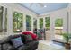 Cozy sunroom featuring large windows, a comfortable seating area, and access to the outdoor deck at 1959 Audubon Ne Dr, Atlanta, GA 30329