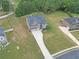 Aerial view showcasing the home's landscaped yard, long driveway, and proximity to other homes and lush greenery at 293 Ironwood Dr, Stockbridge, GA 30281