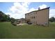 Rear view of a home featuring a patio with outdoor fireplace and lush green lawn at 293 Ironwood Dr, Stockbridge, GA 30281