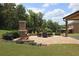 Elegant brick patio featuring an outdoor fireplace and comfortable seating area, surrounded by greenery at 293 Ironwood Dr, Stockbridge, GA 30281