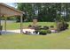 Inviting backyard featuring an outdoor fireplace, patio with furniture, and lush landscaping at 293 Ironwood Dr, Stockbridge, GA 30281