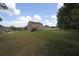 Large backyard with a view of the home, set against a blue sky with fluffy white clouds at 293 Ironwood Dr, Stockbridge, GA 30281