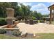 Elegant brick patio featuring an outdoor fireplace and comfortable seating area, surrounded by greenery at 293 Ironwood Dr, Stockbridge, GA 30281