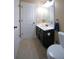 Cozy bathroom with a dark vanity, featuring a white sink, toilet, and a well-lit mirror above at 293 Ironwood Dr, Stockbridge, GA 30281