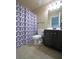 Cozy bathroom features a toilet, vanity with dark wood cabinet, and a shower with a geometric patterned curtain at 293 Ironwood Dr, Stockbridge, GA 30281