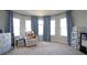 Bright Bedroom with soft carpet, round windows with curtains, and a crib with baby supplies at 293 Ironwood Dr, Stockbridge, GA 30281