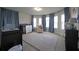 Spacious Bedroom with multiple windows, light blue curtains, plush carpet, and baby furniture at 293 Ironwood Dr, Stockbridge, GA 30281