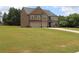 Lush green lawn surrounds a spacious two-story brick home, complete with a three-car garage at 293 Ironwood Dr, Stockbridge, GA 30281