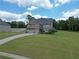 Beautiful two-story home with a well-maintained lawn and long driveway leading to a three-car garage at 293 Ironwood Dr, Stockbridge, GA 30281
