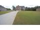 Traditional two-story home boasting a well-manicured lawn and a long driveway leading to a three-car garage at 293 Ironwood Dr, Stockbridge, GA 30281