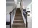 Carpeted stairs with decorative iron railing leading to the main floor at 293 Ironwood Dr, Stockbridge, GA 30281