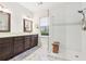 This bathroom boasts a double vanity and a glass shower with a small wooden seat at 3804 Tattenhall Drive Dr, Cumming, GA 30040