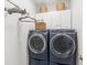 Modern laundry room with blue washer and dryer and white storage cabinets above at 3804 Tattenhall Drive Dr, Cumming, GA 30040