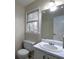 Bathroom with a white toilet, sink, and cabinet. Features a window for natural light at 21 Queen Anne Se Dr, Mableton, GA 30126