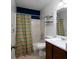 Well-maintained bathroom with a shower, toilet, sink, vanity and a colorful shower curtain at 21 Queen Anne Se Dr, Mableton, GA 30126