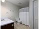 Full bathroom with a standard white sink, toilet and tiled floors. Features a shower with a white curtain at 21 Queen Anne Se Dr, Mableton, GA 30126
