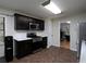 Modern kitchen featuring sleek black cabinetry, stainless steel appliances, and a view into the office at 21 Queen Anne Se Dr, Mableton, GA 30126