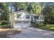 Traditional split level home shows white siding, green shutters, manicured lawn, and an attached two-car garage at 1180 Springs Dr, Canton, GA 30115