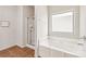 Clean bathroom featuring a tub, shower with glass door, and tile flooring at 2859 Woodward Down Trl, Buford, GA 30519