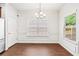 Traditional dining area with bright light fixture, a large window, and elegant wood flooring at 2859 Woodward Down Trl, Buford, GA 30519