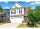 Charming two-story home features a blend of siding and brick with an attached two-car garage at 2859 Woodward Down Trl, Buford, GA 30519