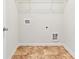 Compact laundry room area with tiled flooring and shelving at 2859 Woodward Down Trl, Buford, GA 30519