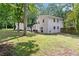 Expansive backyard with a white two-story house, patio, green lawn, and lush trees at 431 Hickory Se Ln, Smyrna, GA 30082