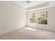 Bright bedroom with plush carpet and a large window providing views of the neighborhood at 230 E Ponce De Leon Ave # 104, Decatur, GA 30030
