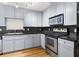 Modern kitchen with stainless steel appliances, dark countertops, and sleek gray cabinetry at 230 E Ponce De Leon Ave # 104, Decatur, GA 30030