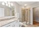 Bathroom featuring a granite countertop vanity, mirror, shower, and a walk-in closet at 950 W Peachtree Nw St # 812, Atlanta, GA 30309