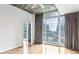 Bedroom with hardwood floors, large windows, and access to a balcony with city views at 950 W Peachtree Nw St # 812, Atlanta, GA 30309