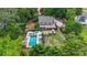 Aerial view features an in-ground pool, hot tub, covered patio, and mature trees on a lush lot at 9805 Buice Rd, Alpharetta, GA 30022