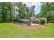 Expansive property featuring a home with a screened-in pool, surrounded by green lawn and mature trees at 9805 Buice Rd, Alpharetta, GA 30022