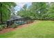 Scenic backyard view featuring a screened pool area and a well-maintained lawn surrounded by mature trees at 9805 Buice Rd, Alpharetta, GA 30022